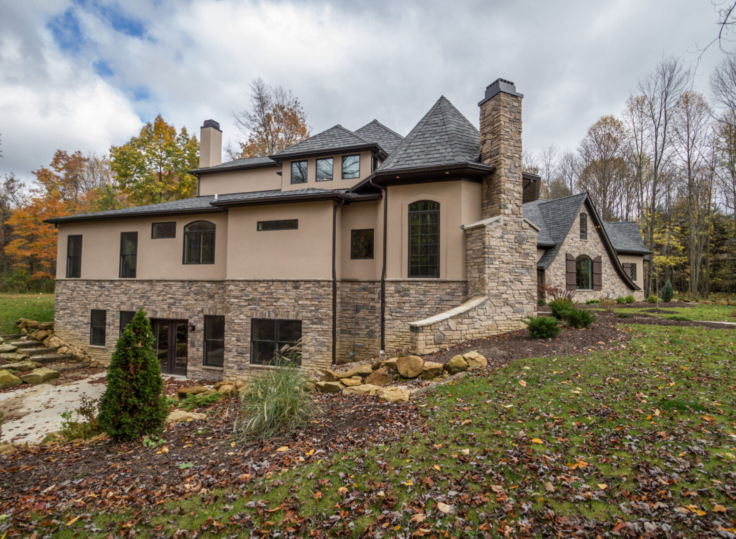 A large house with a lot of windows and a big stone wall.