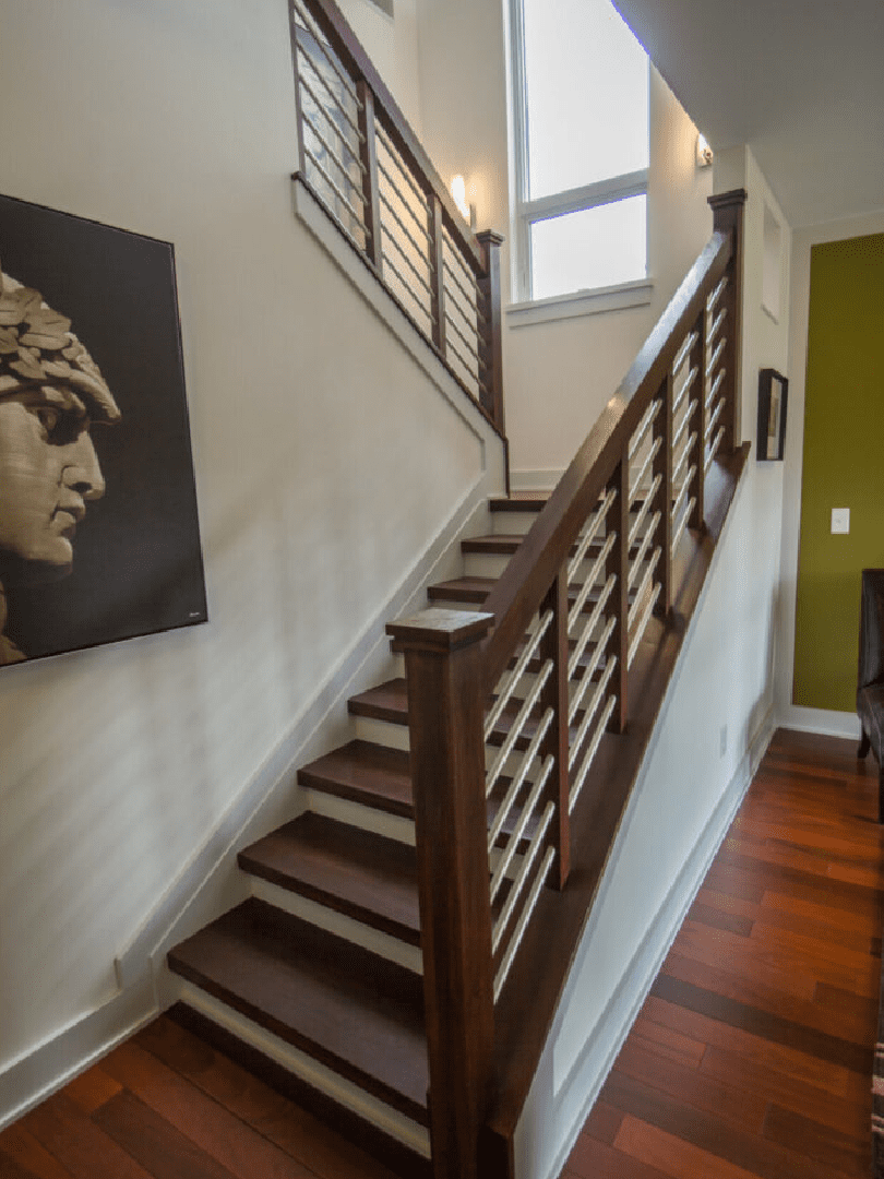 A staircase with wood railing and metal handrails.