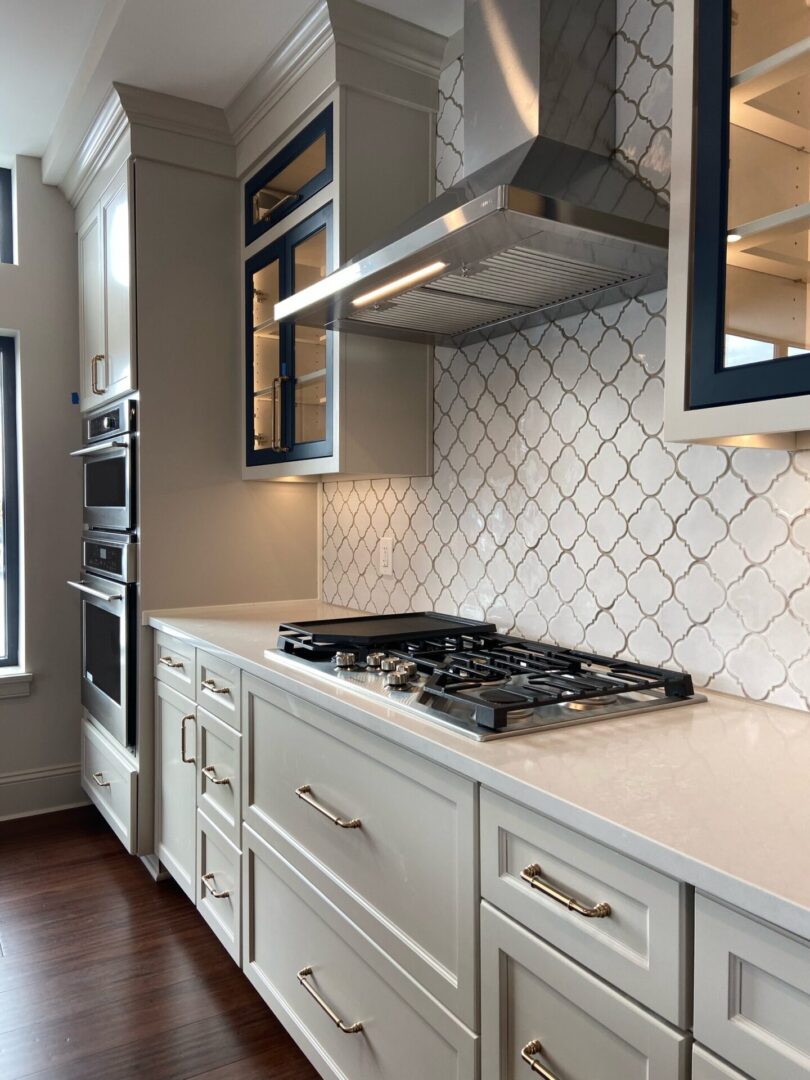 A kitchen with white cabinets and a stove.