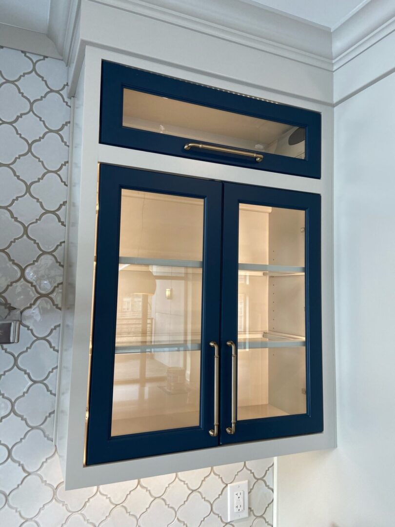 A blue cabinet with glass doors and a light.